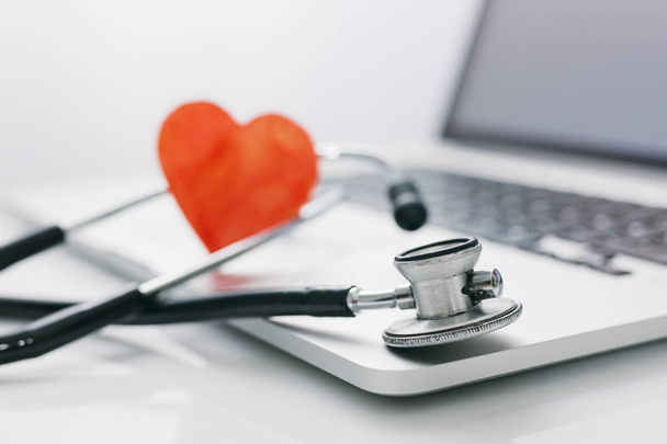 Stethoscope with laptop keyboard and red paper heart, medical concept. - Photo, Image