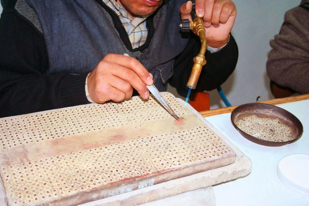 Рабочие руки производят серебряные украшения
 - Фото, изображение