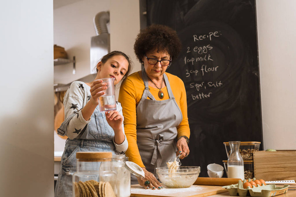 Food brings everyone together. grandmother and her granddaughter baking together at home - 写真・画像