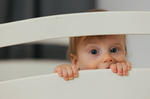 portrait of baby peeking from crib - Fotó, kép