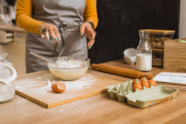 close up of senior woman hands preparing dough in kitchen - Valokuva, kuva