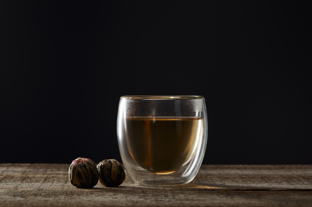 transparent glass with blooming tea isolated on black with copy space - Foto, immagini