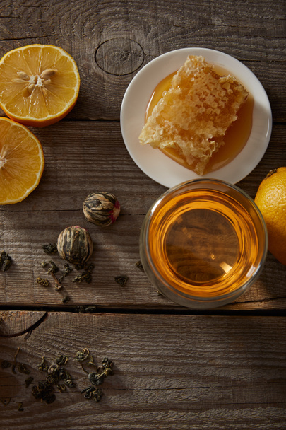 vista superior del té chino en flor en vidrio, limones y panal de abeja en mesa de madera
 - Foto, Imagen