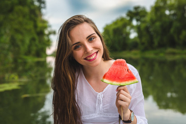 woman with watermelon outdoor by the river - 写真・画像