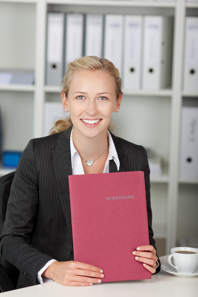 Young Confident Businesswoman Holding Application File At Desk - Φωτογραφία, εικόνα