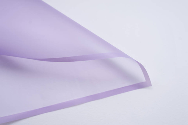 transparent paper corner with lilac edges on white background - Фото, изображение