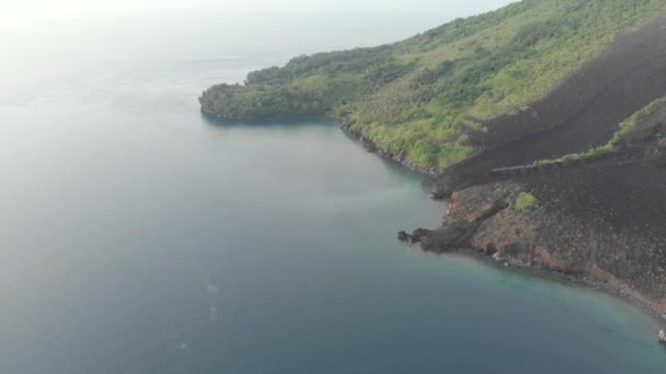 Aérea: volando sobre las Islas Banda volcán activo Gunung Api flujos de lava Maluku Indonesia exuberante bosque verde turquesa agua arrecife de coral pintoresco destino de viaje. Perfil de color D-log cinelike nativo
 - Metraje, vídeo