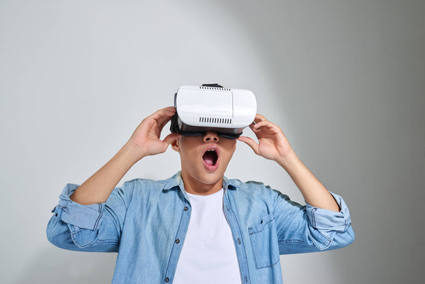 Asian young man wearing virtual reality headset.  - Foto, afbeelding
