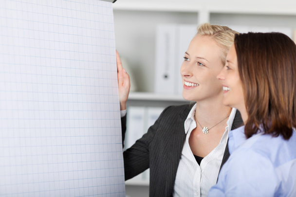 Smiling Businesswoman Standing By Flipchart - Foto, afbeelding