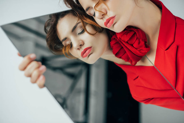  beautiful young woman with closed eyes holding mirror on white - Valokuva, kuva