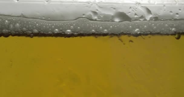Koud licht bier in een glas. Ambachtelijke bier close-up macro. Rotatie 360 graden - Video