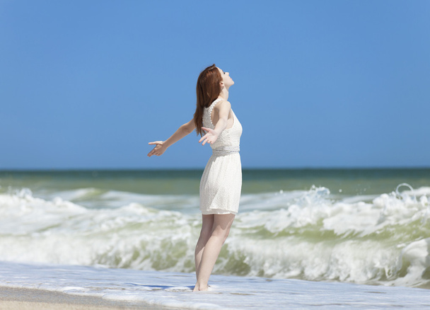 Redhead girl on the beack in spring time - Foto, afbeelding