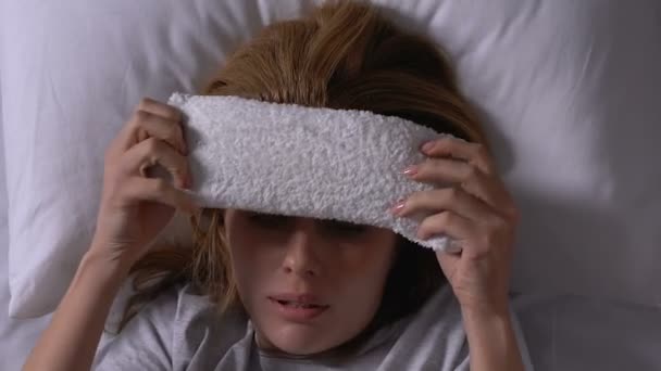 Beteg nő az ágyban üzembe törölköző a homlokán, szenved influenza, kezelés - Felvétel, videó