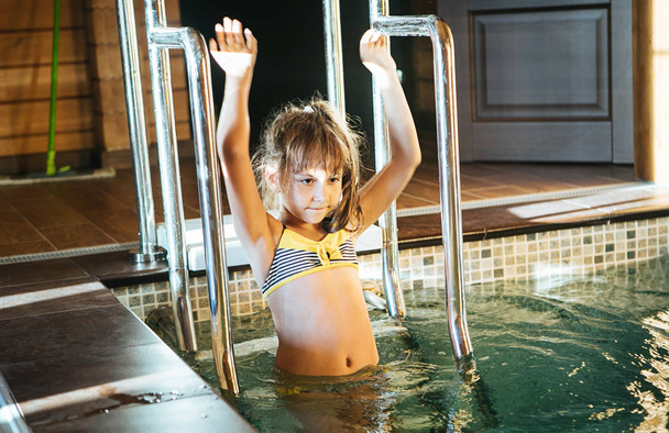 Little girl in a swimmin g pool - 写真・画像