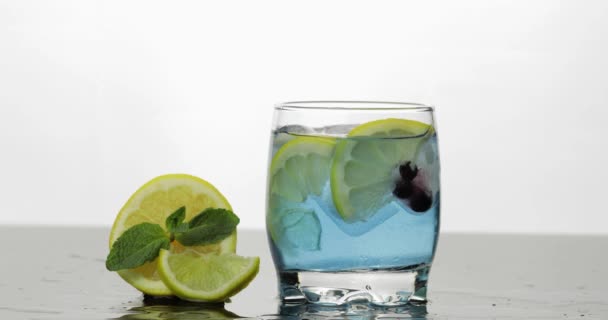 Añadir hojas de menta en un vaso con bebida fría, lima, limón, grosellas, hielo
 - Metraje, vídeo