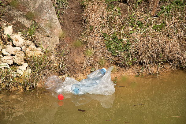 Poluição do plástico na água. Os resíduos de plástico flutuam na água. Protecção do ambiente. Garrafas de plástico e outro lixo na água
. - Foto, Imagem