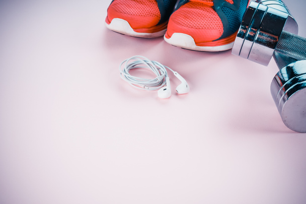 urheilu käsite: lenkkarit, käsipainot, kuulokkeet vaaleanpunainen backgr
 - Valokuva, kuva