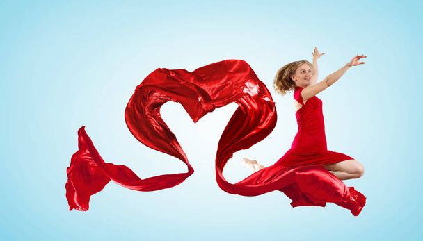 Young woman dancing with red fabric in studio and heart symbol - Фото, изображение