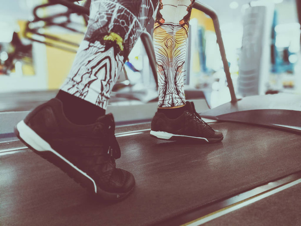 feet in sneakers on a treadmill - Foto, afbeelding