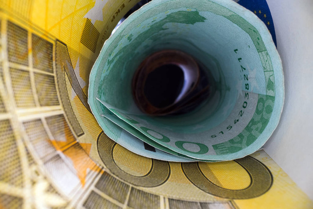金のトンネルの中チューブに巻かれたユーロバックノートの抽象的な視点。お金の節約と投資 - 写真・画像