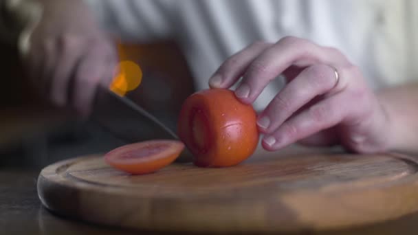 The cook cuts fresh red tomatoes on the wooden board in a bar in slow motion, cooking fresh vgetable salad, vegetarian food and meals, 4k UHD 60p Prores HQ 422 - Footage, Video