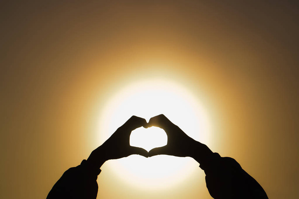 Femme faisant forme de coeur pendant le lever du soleil, Dieu est concept d'amour, H
 - Photo, image