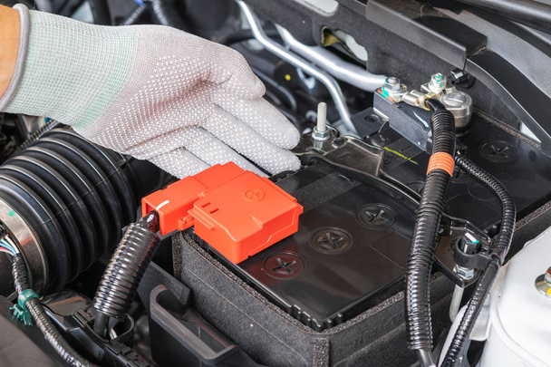 Técnico comprobar la batería terminal del coche
 - Foto, imagen