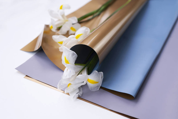 flowers (white irises) in the soft golden floristic package - Fotó, kép