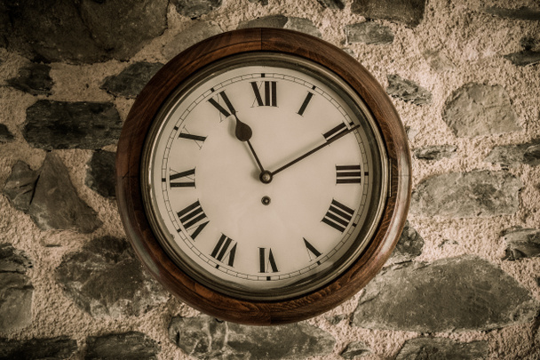 Vintage wooden wall clock on stone wall - Photo, Image