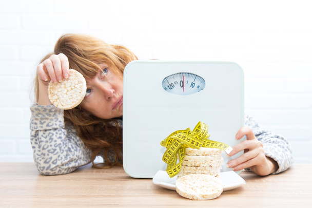 diet and slimming concept, corn cakes with tape measure and girl - Photo, Image