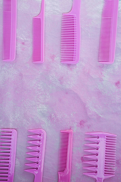 Pink bright comb for hairdressers. Beauty saloon. Tools for hairstyles. Pink background. Barbershop. Set of different hairbrushes. Space for text. - Photo, Image