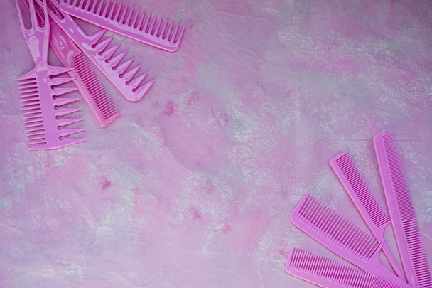 Pink bright comb for hairdressers. Beauty saloon. Tools for hairstyles. Pink background. Barbershop. Set of different hairbrushes. Space for text. - Photo, Image