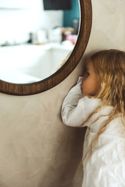 little girl standing near mirror - Foto, afbeelding