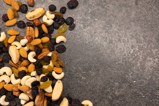 Maukkaita orgaanisia eri pähkinöitä tummalla pöydällä. Terveellinen ruoka ja välipala
. - Valokuva, kuva