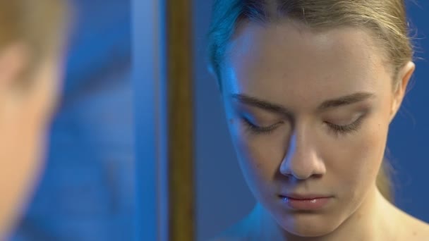 Αναστατωμένος θηλυκός έφηβος κοιτάζοντας άσχημη λέξη γραμμένο στον καθρέφτη, εκφοβισμός θύμα - Πλάνα, βίντεο