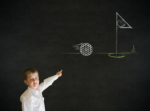 Pointing boy dressed up as business man with chalk golf ball flag green on blackboard background - Фото, изображение