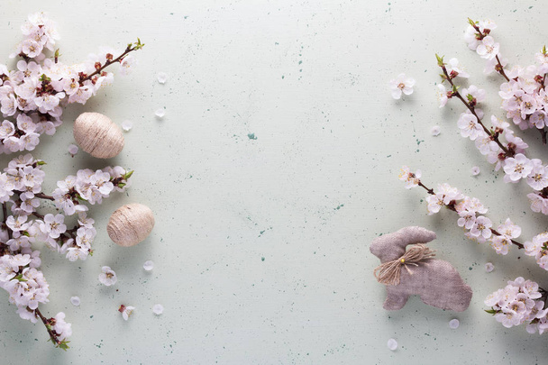 Счастливой Пасхи. Состав цветущих ветвей, пасхальный кролик и яйца ручной работы
 - Фото, изображение