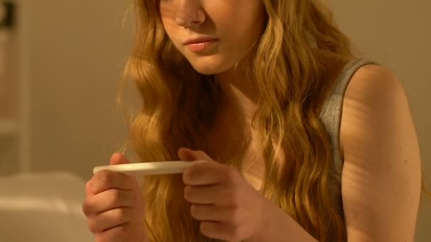 Happy female teenager holding pregnancy test with negative result, sex education - Felvétel, videó