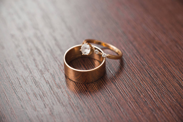 arany gyűrű az ifjú házasok egy fából készült asztal - Fotó, kép
