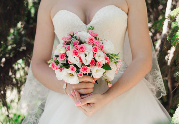 Braut im weißen Kleid im Wald hält Hochzeitsstrauß - Foto, Bild