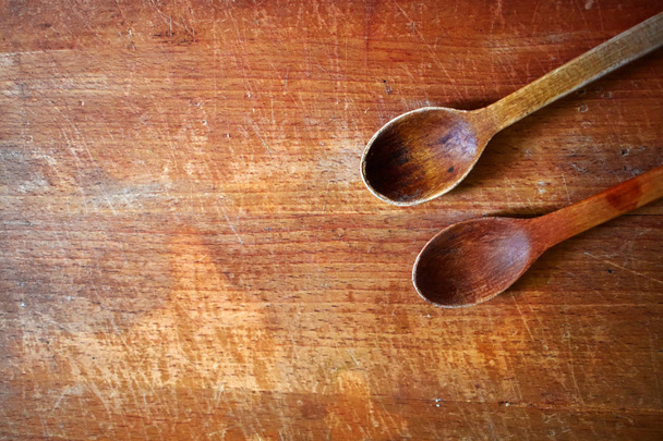 Two wooden spoons on the wooden chopping board, background - Photo, Image