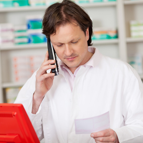 pharmacist looking serious while on call - Foto, afbeelding