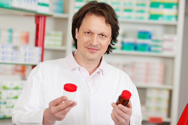 pharmacist looking at medicine bottles - Zdjęcie, obraz