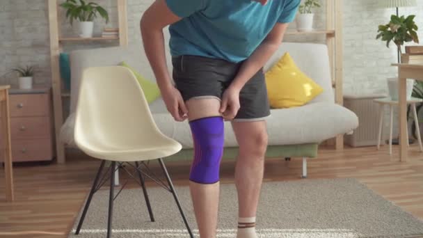 Primo piano di un atleta uomo dopo un infortunio tira una benda sul ginocchio
 - Filmati, video