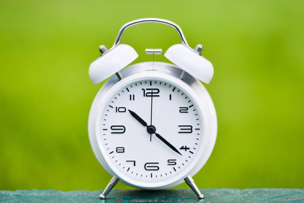 White alarm clock on green background. - Photo, Image