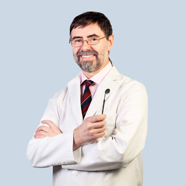 Портрет счастливого стоматолога средних лет на бледном фоне, носить
 - Фото, изображение