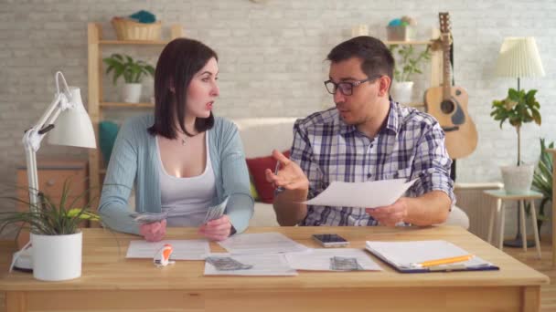 Young couple concerned and tense, doing the calculations documents with calculator - Video