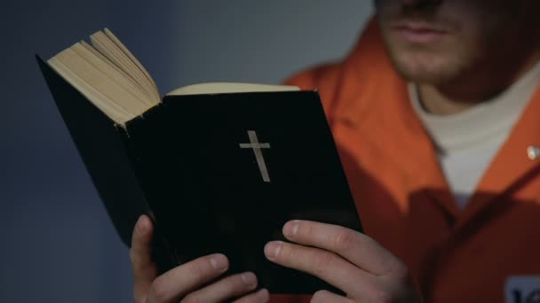 Więzień w kajdankach czytania Świętej Biblii, skruchy za grzechy, wiara i nadzieja - Materiał filmowy, wideo