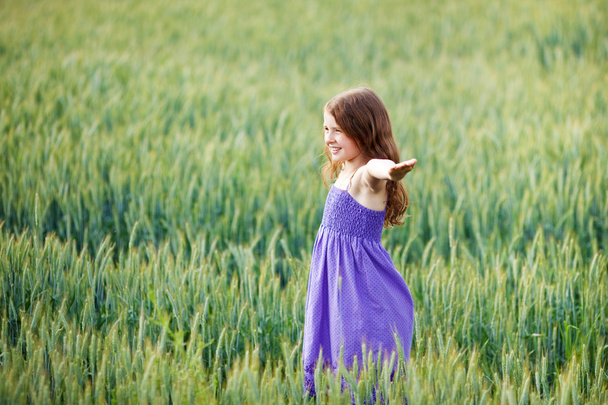 Молода дівчина грає на полі пшениці
 - Фото, зображення
