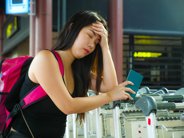 young stressed and exhausted Asian Chinese woman at airport terminal feeling tired and worried missing connection flight or suffering delay on holidays travel  - Foto, Imagen